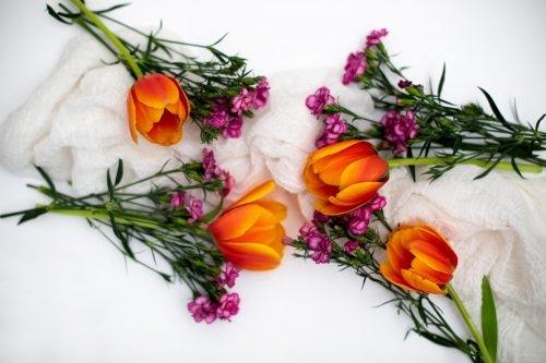 yellow and pink tulips on white textile